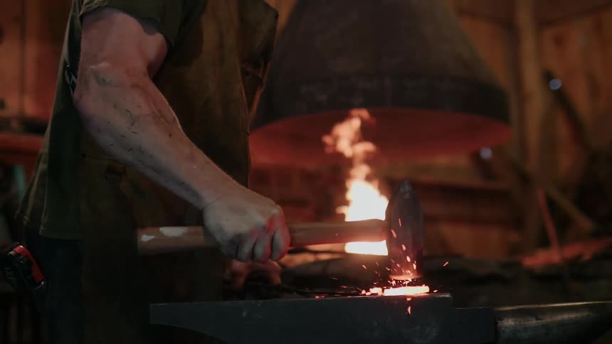 A blacksmith hammers heated metal