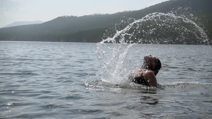 A person jumps up out of the water
