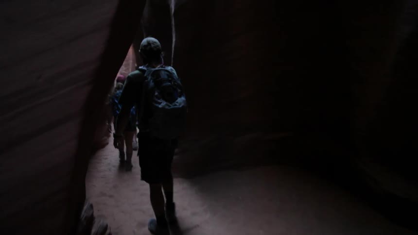 Hikers walk through a rocky canyon