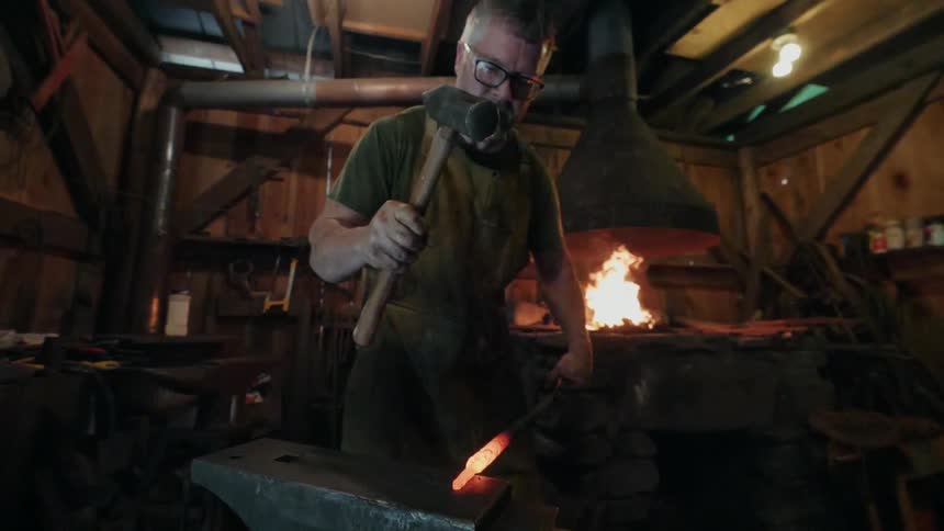 A man is working hammering hot metal