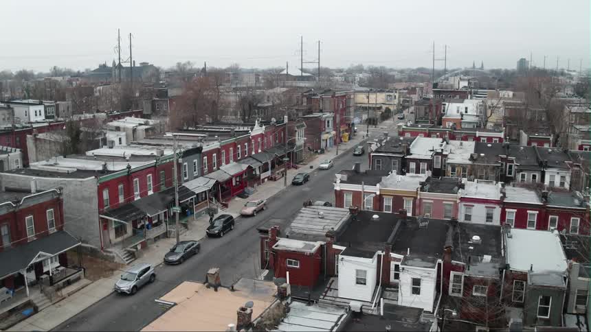 The town is full of homes and people traveling on a cloudy day