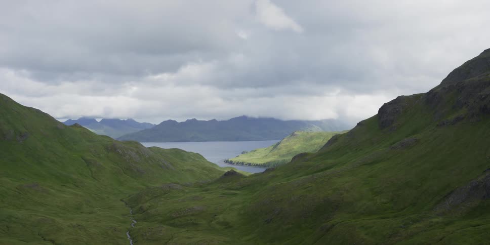 Clouds float over mountains and sea