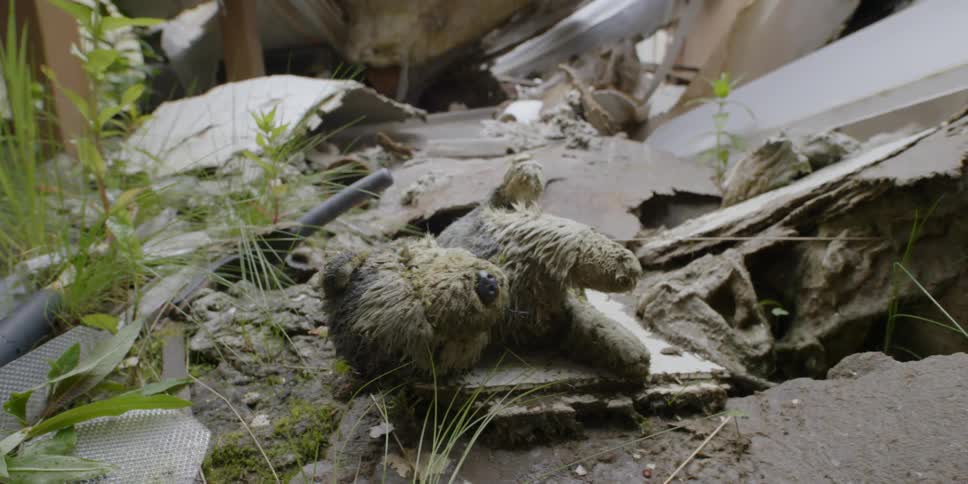 A stuffed teddy bear is covered in mud