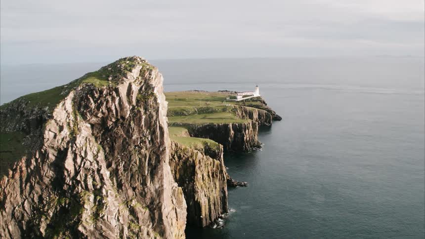 Mountain peninsula with lighthouse stretching out into the ocean