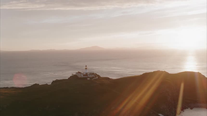 The sun sets over a lighthouse