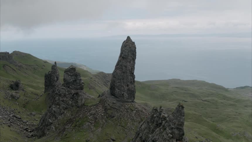 Rocks are jetting out from a green hillside