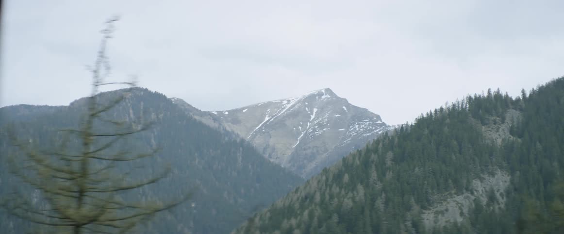 A car drives passed a snowy mountain top view