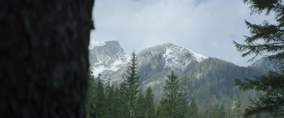 Clouds hover over snowy mountain peaks