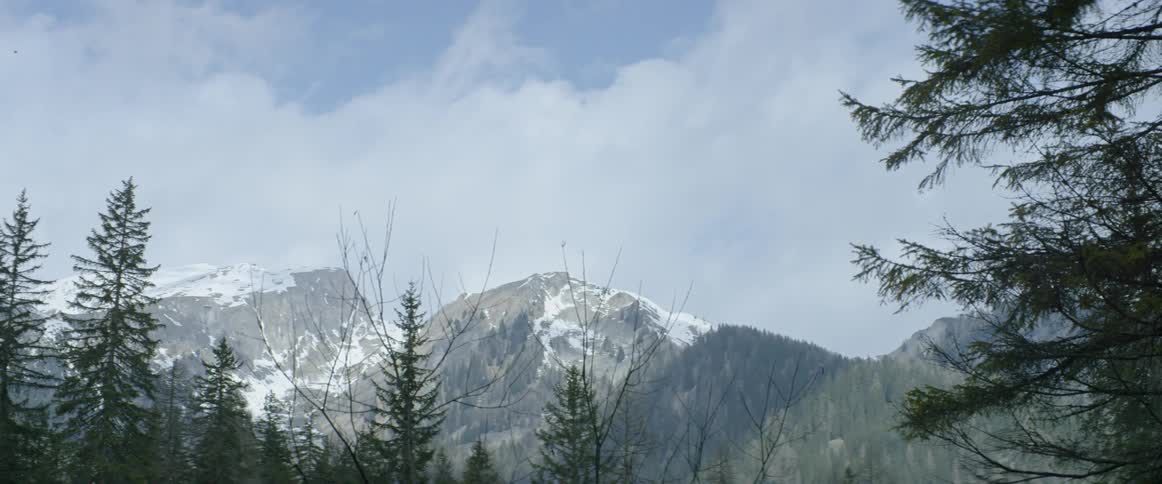 Clouds float over snowy mountain peaks