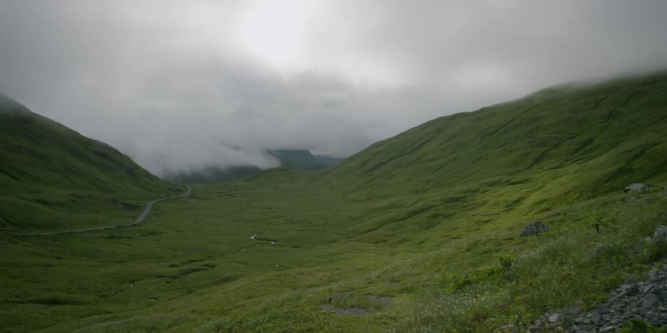 Clouds rolling into a valley