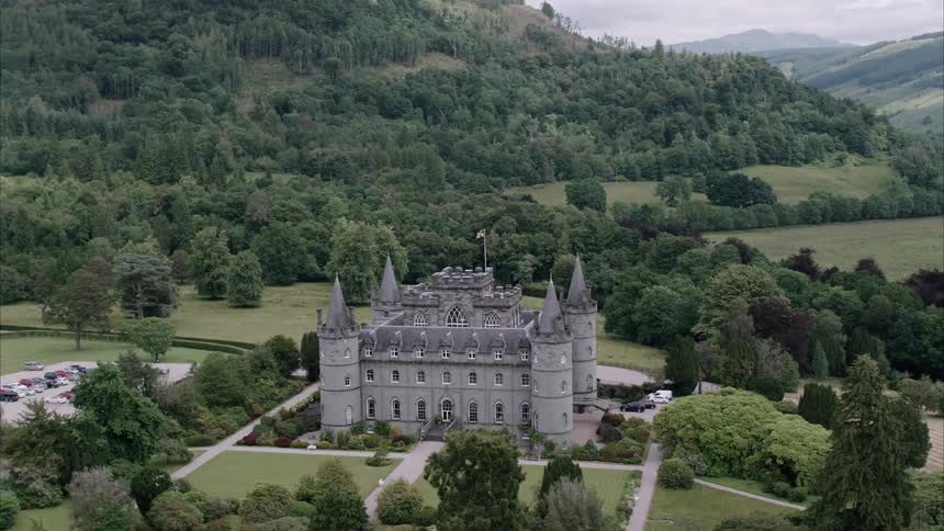 A stone manor is surrounded by trees