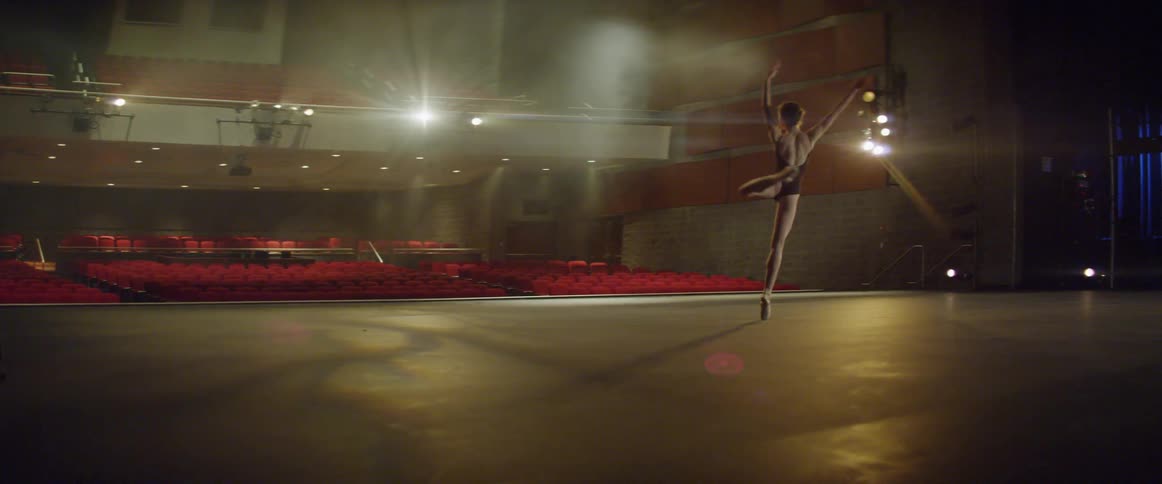 A ballet dancer is practicing on stage
