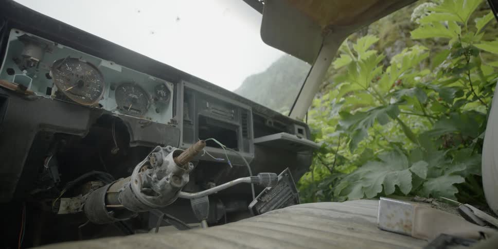 Rain falls onto an abandoned vehicle
