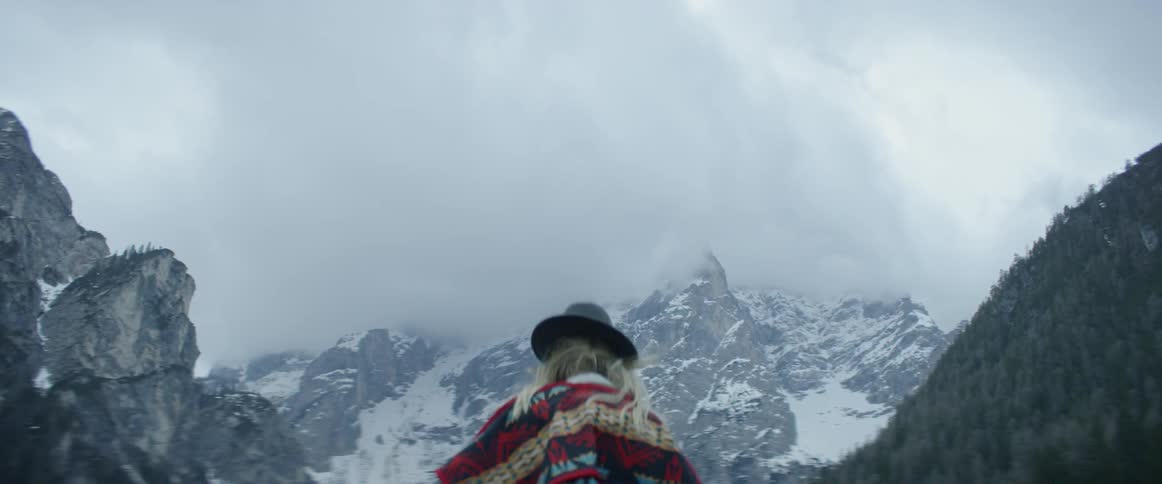 A woman stands in snowy mountains