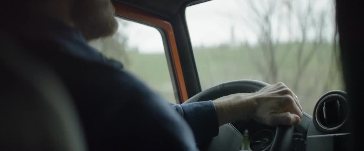 A man drives a vehicle through a forested area