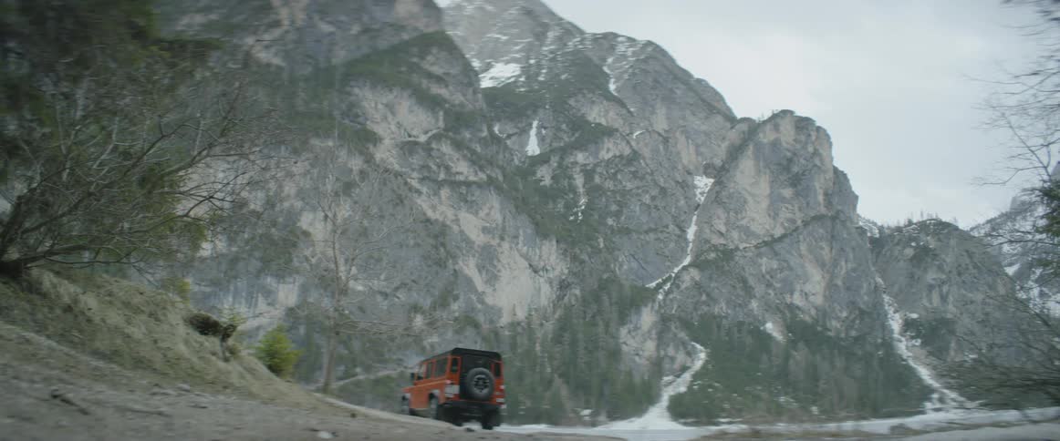 A truck drives towards the tall mountain