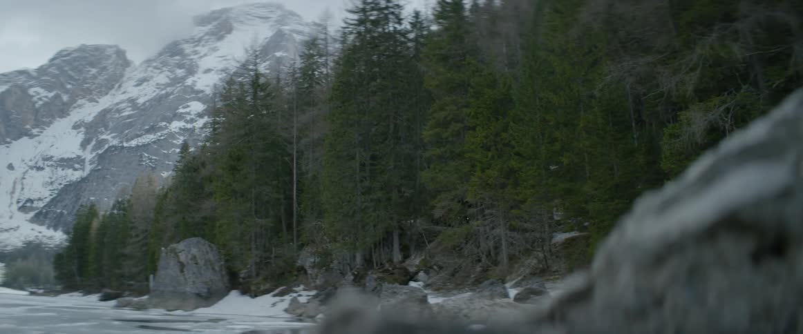 Snow and ice on a mountain and a rocky river bank
