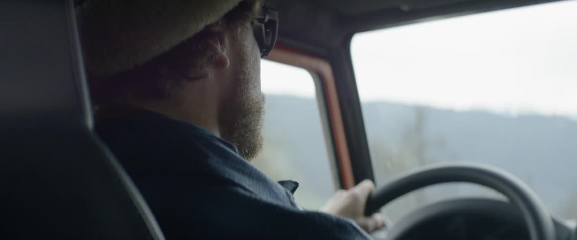 A man drives a car in the mountains
