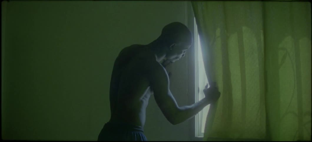 A man is peaking out of a curtain