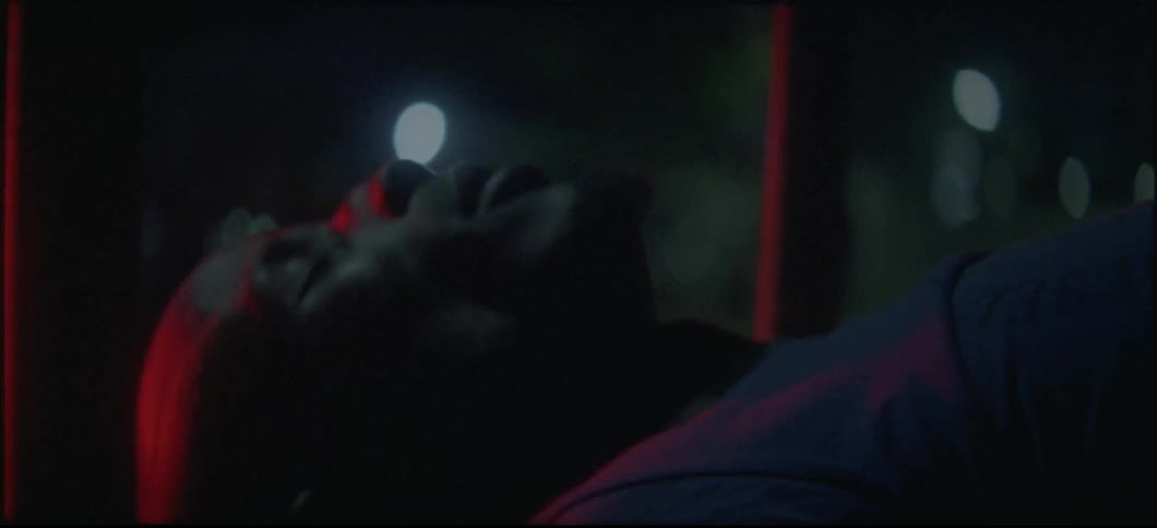 Man laying down in between two bars at night