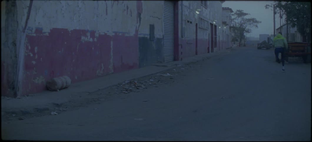 A man runs around the corner down the street