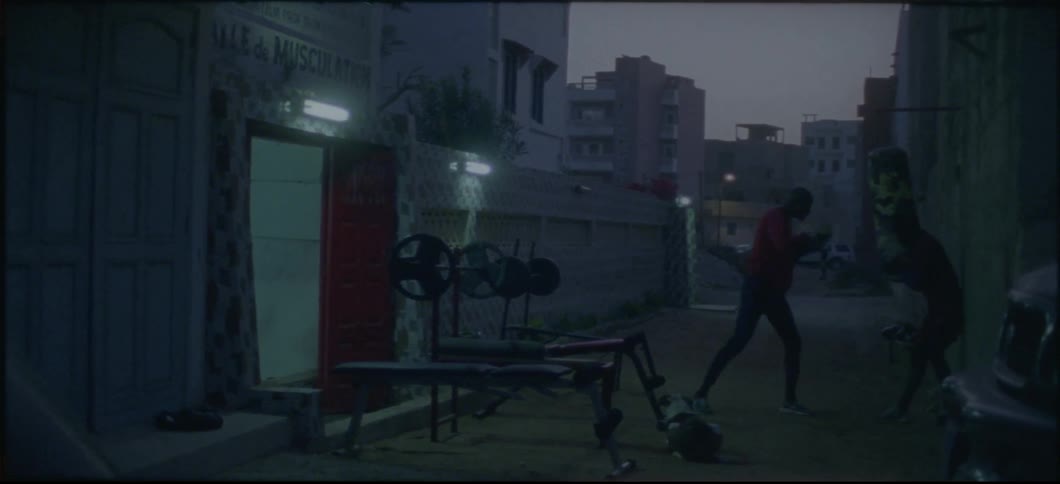 A man is punching a heavy bag in the alley