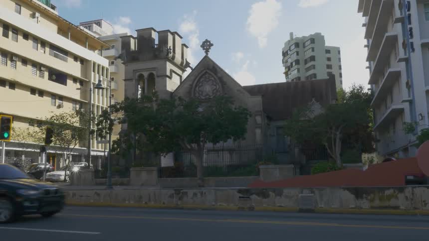 An old church surrounded by apartment type buildings in an urban area