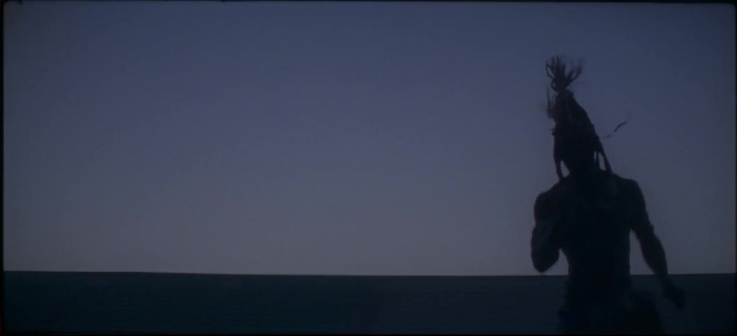 A man bounces outside while wearing a headdress at dusk