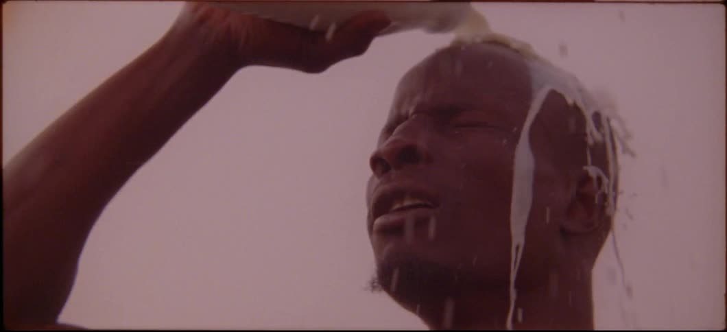A man is pouring white liquid over his head