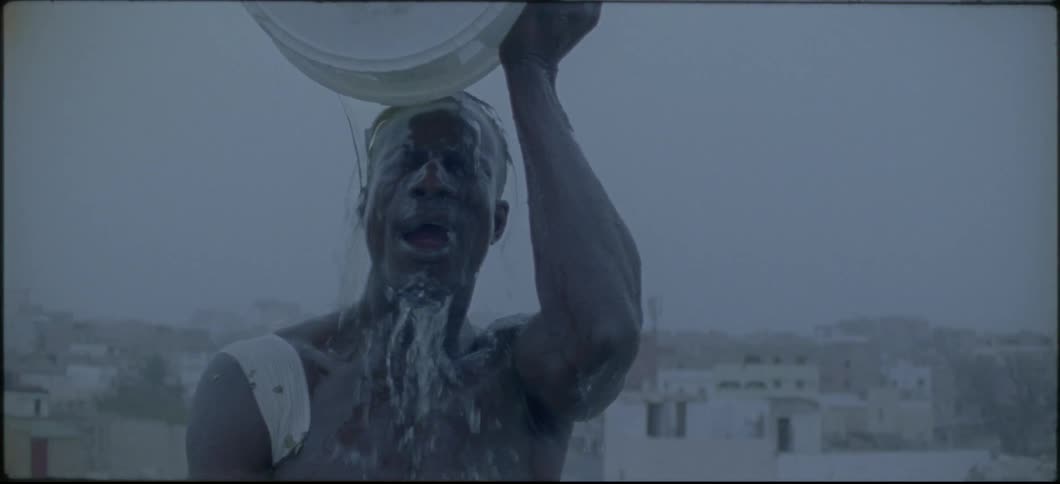 A man dumps a bucket of water over his head