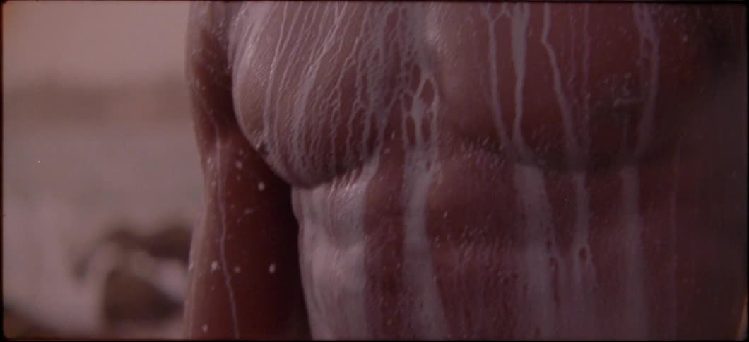A man with white streaks down his body is standing without a shirt on