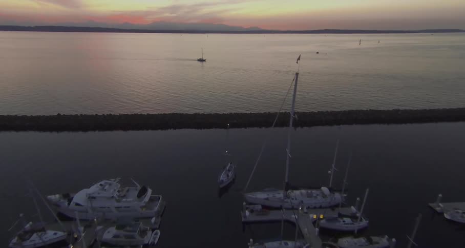 Boats float in a marina at sunset