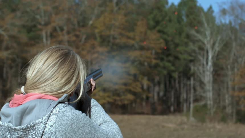 Woman shooting a gun in slow motion
