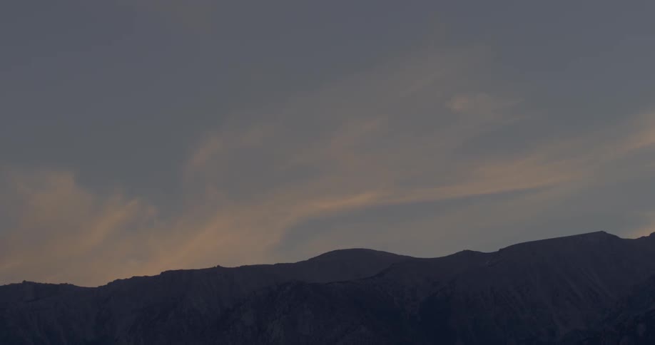 Thin clouds over a mountain at dusk