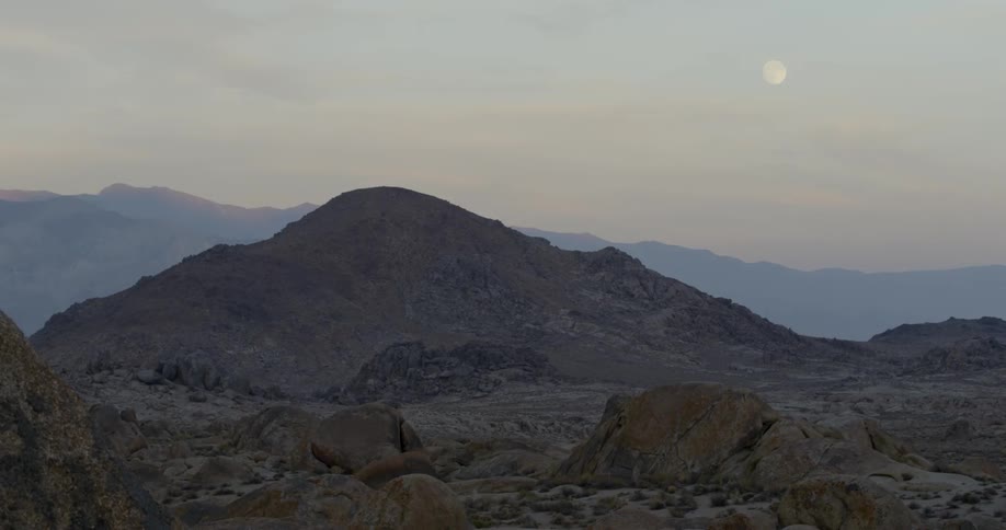 The moon over a desolate mountainous area