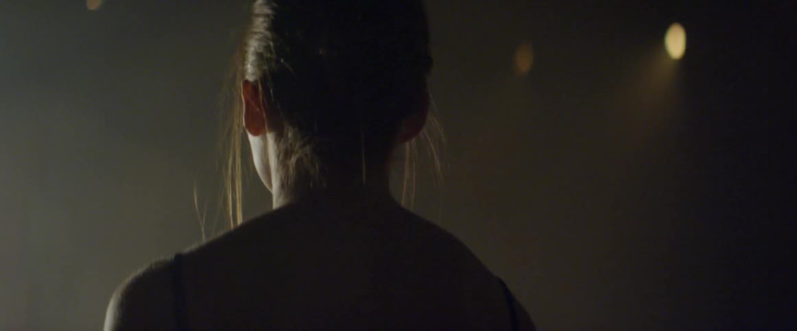 A dancer stretches under a light
