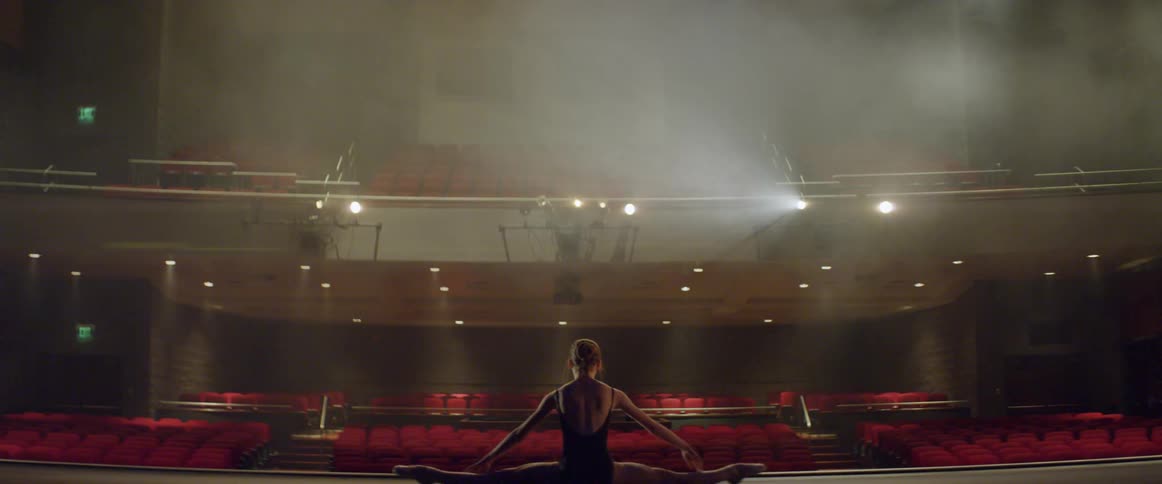 Woman practices ballet moves on a stage