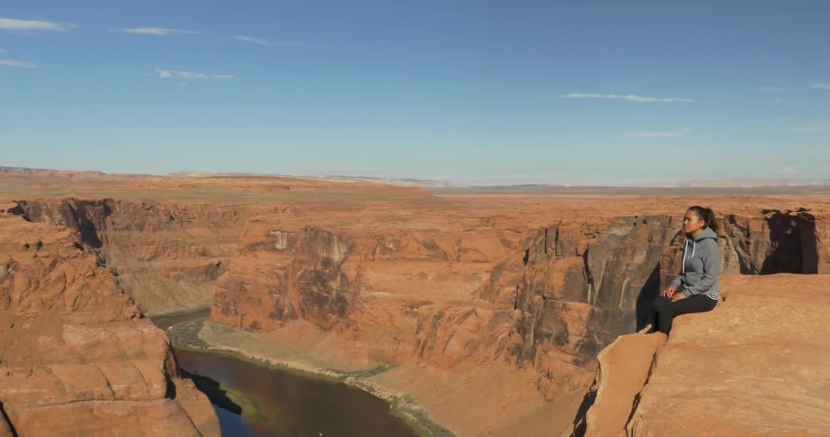Woman sitting on the edge of a cliff