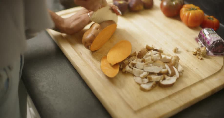 Woman chops a sweet potato