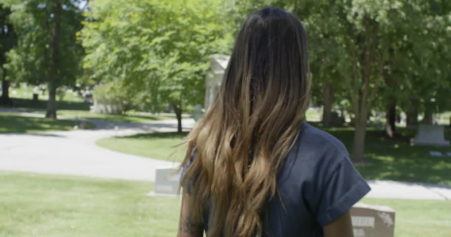 A woman walks through a cemetery