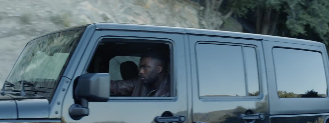 A man drives a jeep on a bumpy mountain road