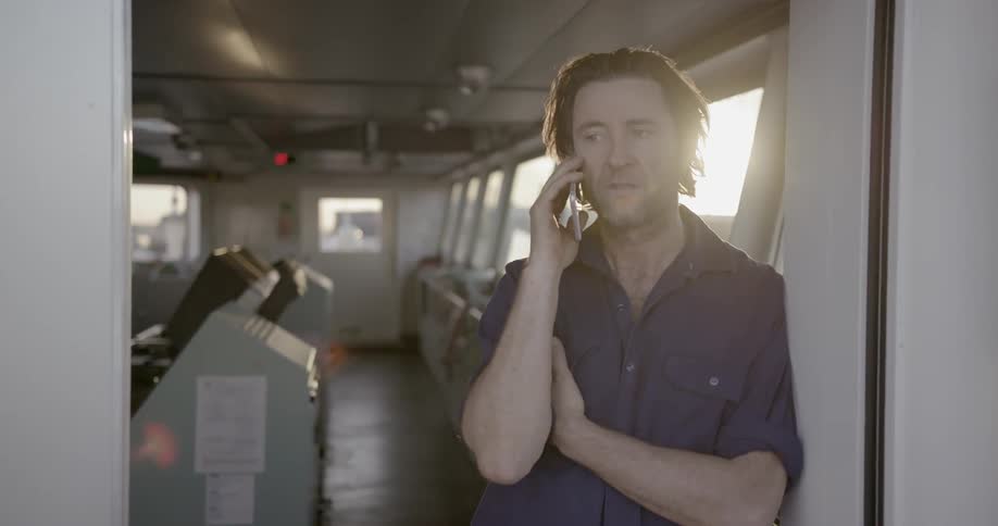 Man talks on a cell phone while leaning on a door frame