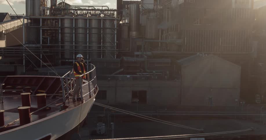 Man leans on a railing at the edge of a ship