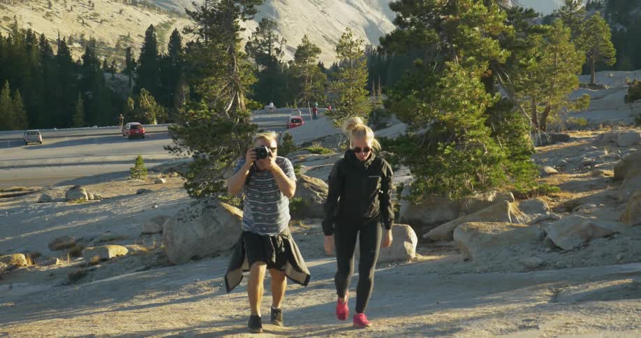 Man and woman walking uphill on a sunny day