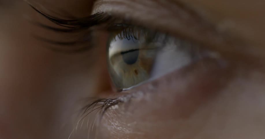 A woman is opening her eye during the day