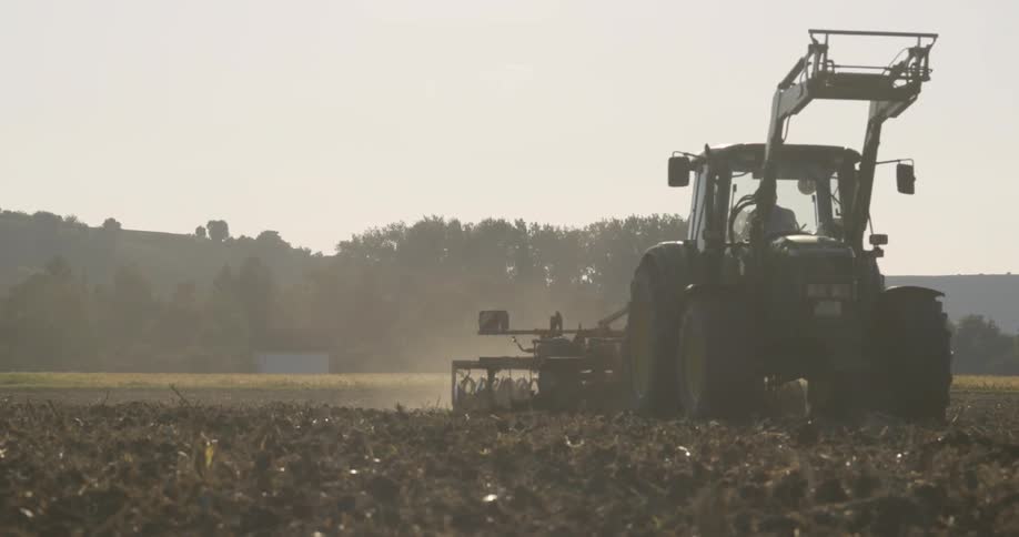 Farm equipment works the fields