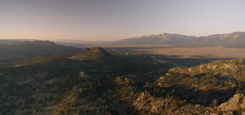 Dusk is settling over a desert valley and mountains