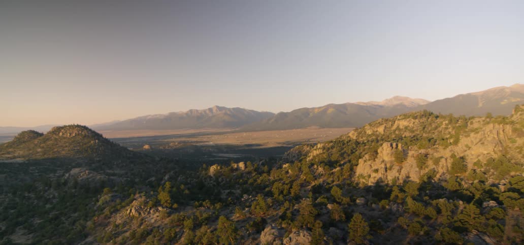 A mountain valley is shown at sunset