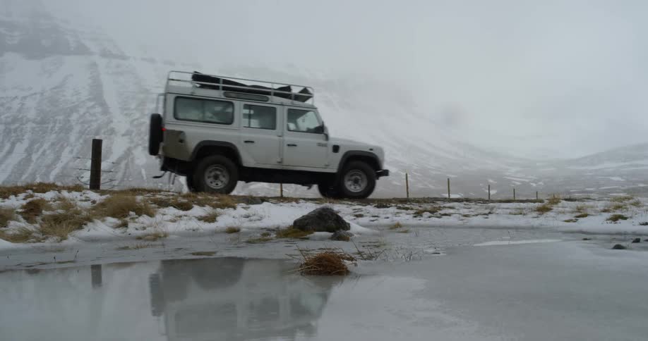 Vehicle passing a frozen pond in a winter environment