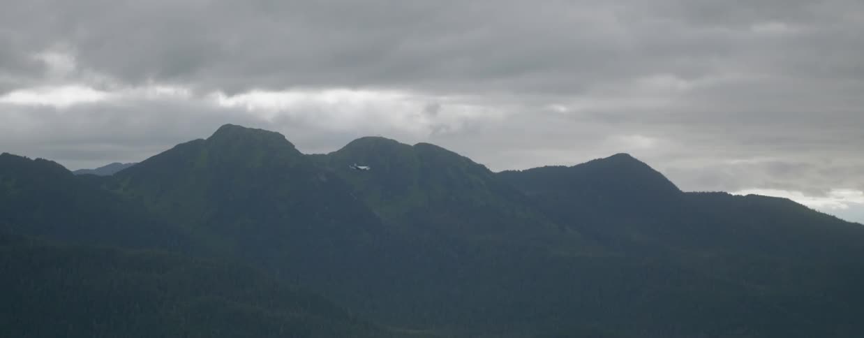 Helicopter flies past mountain range